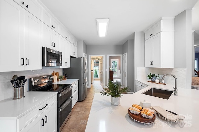 1214 Foxfield Rd, Waxhaw, NC 28173 - kitchen featuring stainless steel appliances, a sink, decorative backsplash, and white cabinets