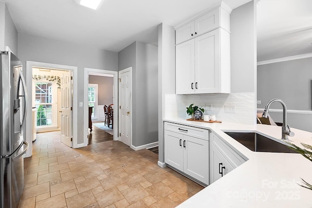 1214 Foxfield Rd, Waxhaw, NC 28173 - kitchen with stainless steel fridge with ice dispenser, a sink, stone finish flooring, baseboards, and light countertops