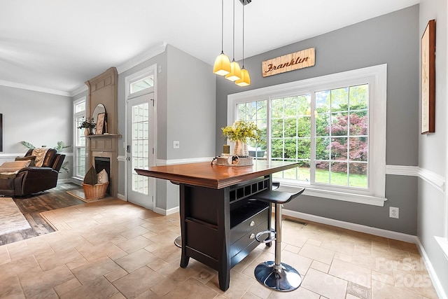 1214 Foxfield Rd, Waxhaw, NC 28173 - dining space featuring baseboards, crown molding, light stone finish flooring, and a fireplace