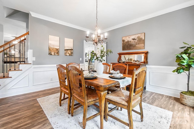 1214 Foxfield Rd, Waxhaw, NC 28173 - dining area with crown molding, a chandelier, wood finished floors, stairs, and a wainscoted wall