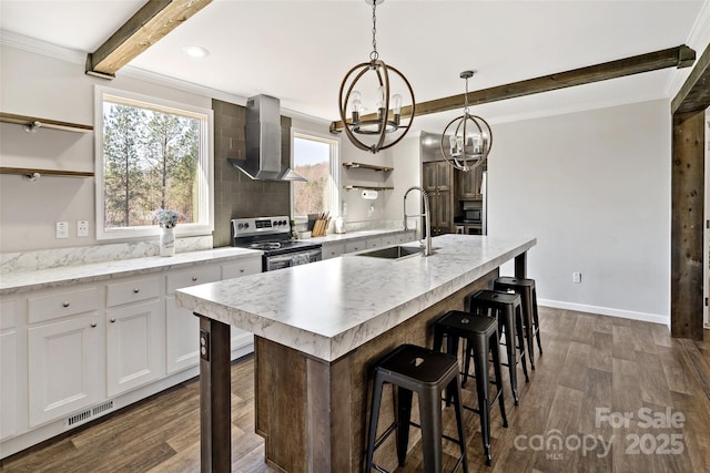kitchen featuring wall chimney exhaust hood, stainless steel range with electric cooktop, a sink, open shelves, and an inviting chandelier