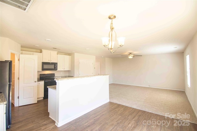 kitchen featuring white cabinets, visible vents, dark wood-type flooring, hanging light fixtures, and black appliances