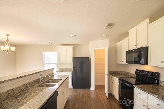 kitchen with white cabinetry, dark stone countertops, a sink, dark wood-style floors, and black appliances