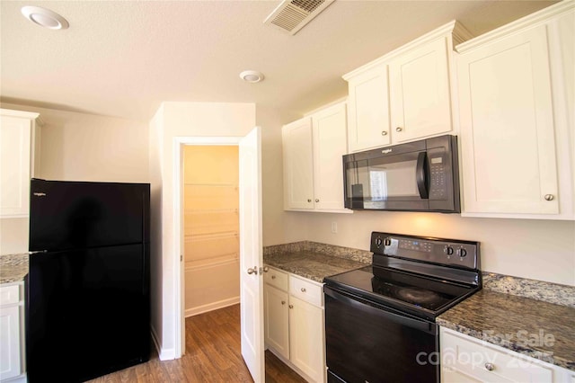 kitchen with visible vents, black appliances, wood finished floors, and white cabinetry