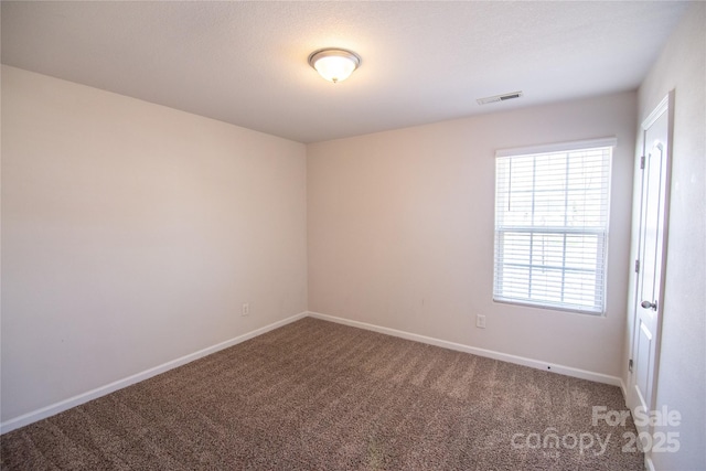 empty room featuring baseboards, carpet flooring, and visible vents