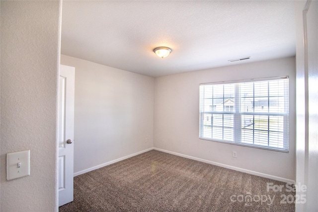 carpeted spare room with baseboards and visible vents