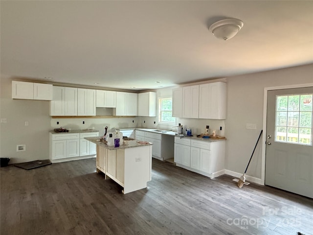 kitchen featuring a kitchen island, dark wood-style flooring, and white cabinets