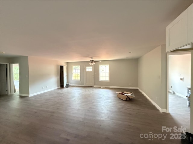 unfurnished living room featuring baseboards, wood finished floors, and a ceiling fan