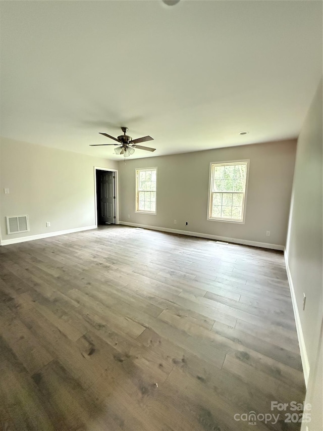 unfurnished room featuring baseboards, wood finished floors, and a ceiling fan