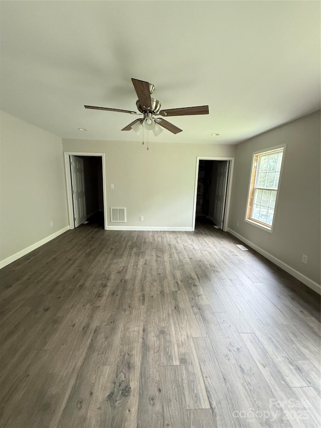 unfurnished room with dark wood finished floors, ceiling fan, and baseboards