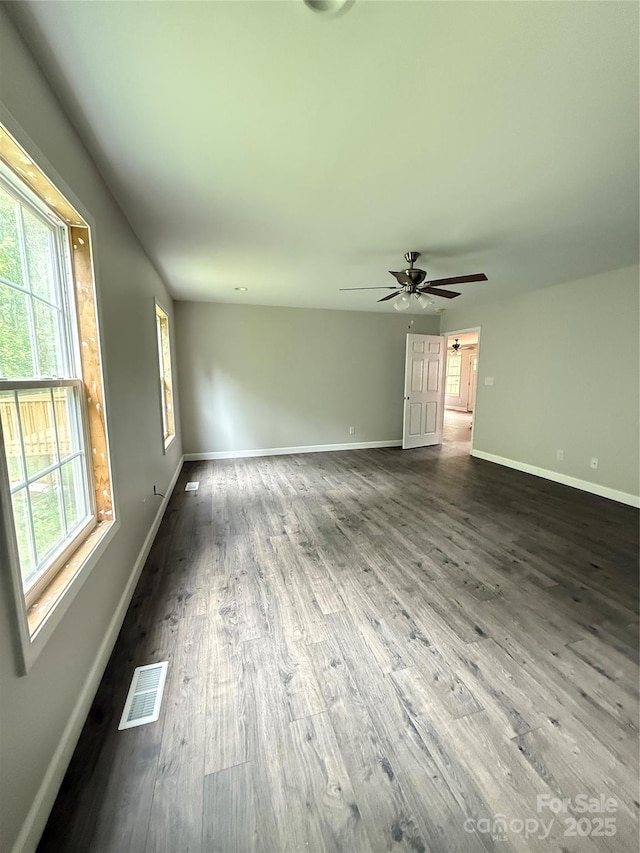 empty room with wood finished floors, baseboards, and ceiling fan