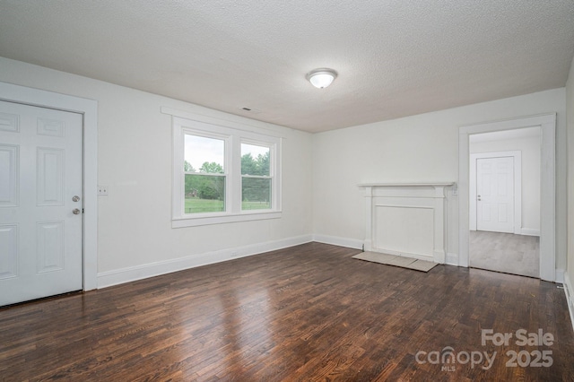 201 Lee Black Rd, Cherryville, NC 28021 - unfurnished living room with dark wood finished floors, baseboards, and a textured ceiling