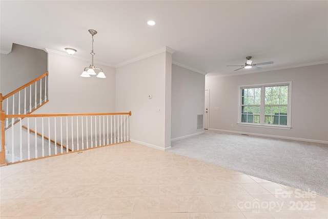 spare room featuring ornamental molding, light tile patterned floors, baseboards, light colored carpet, and ceiling fan