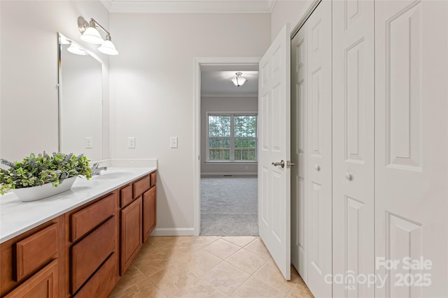 bathroom with tile patterned flooring, baseboards, crown molding, and vanity