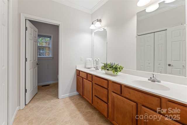 full bath with double vanity, baseboards, a sink, and ornamental molding