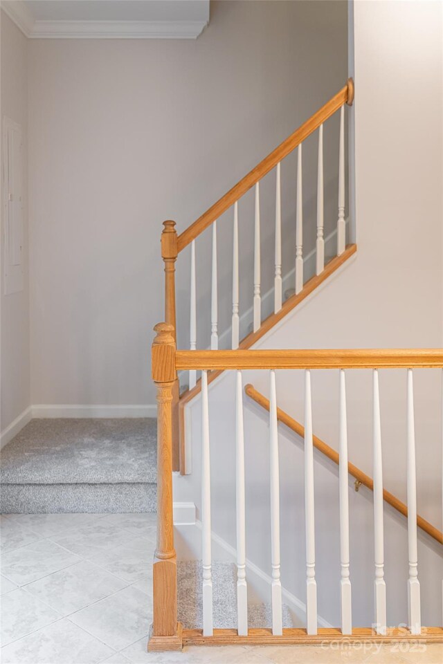 stairway with tile patterned floors, baseboards, carpet floors, and crown molding