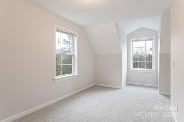 bonus room with light carpet, lofted ceiling, and baseboards