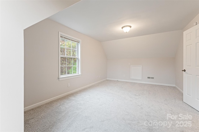 additional living space with lofted ceiling, visible vents, carpet flooring, and baseboards