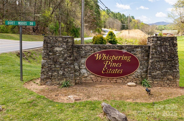 community sign with a lawn and a mountain view