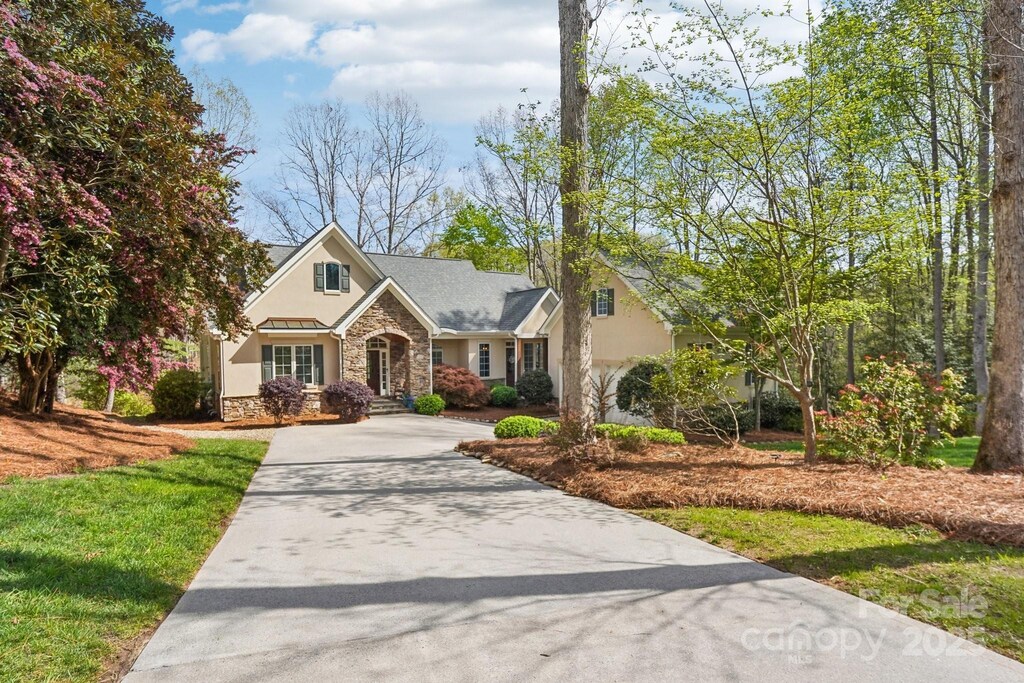 176 Sunset Bay Dr, Troutman, NC 28166 - view of front of home featuring stone siding, driveway, stucco siding, and a front lawn