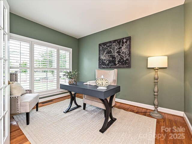 office space with baseboards and wood finished floors