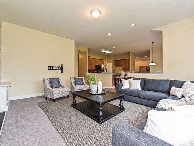 living area with dark carpet, recessed lighting, and baseboards