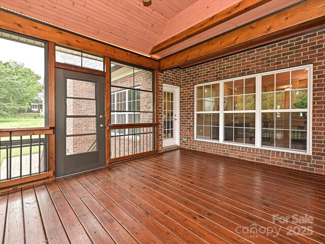 unfurnished sunroom with vaulted ceiling, brick wall, hardwood / wood-style floors, wooden ceiling, and a deck