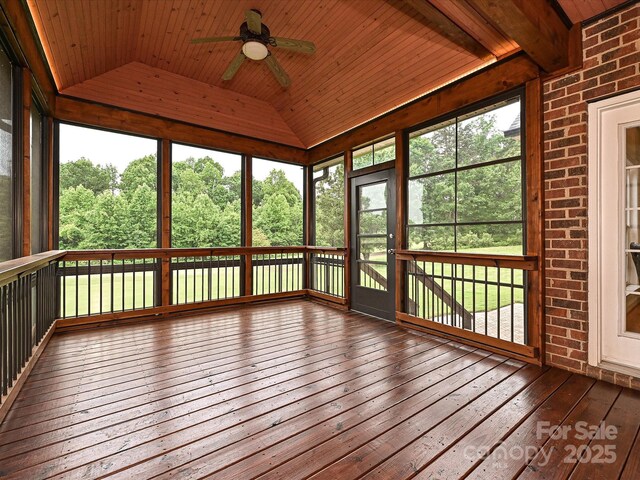 unfurnished sunroom featuring lofted ceiling, ceiling fan, and plenty of natural light