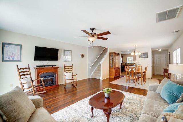309 River Clay Rd, Fort Mill, SC 29708 - living area with stairs, ceiling fan with notable chandelier, visible vents, a glass covered fireplace, and wood finished floors