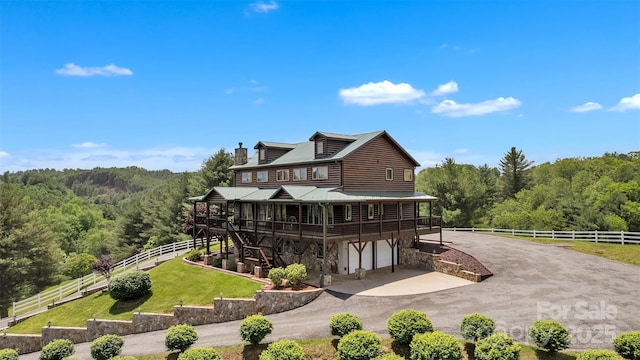 199 Joriann Dr, Crumpler, NC 28617 - rear view of property with a forest view, a chimney, stone siding, a garage, and a wooden deck