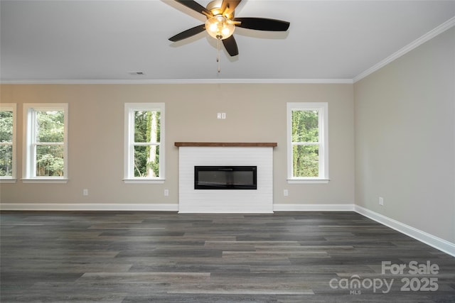 unfurnished living room featuring a ceiling fan, a healthy amount of sunlight, crown molding, and a glass covered fireplace