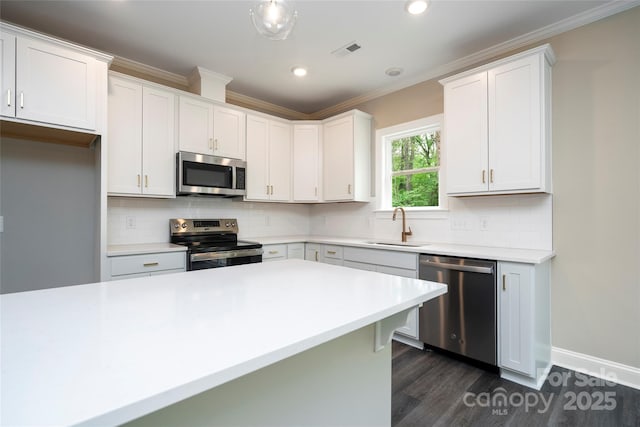 kitchen featuring a sink, stainless steel appliances, dark wood-type flooring, crown molding, and visible vents