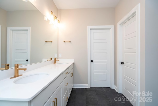 bathroom featuring double vanity, baseboards, and a sink
