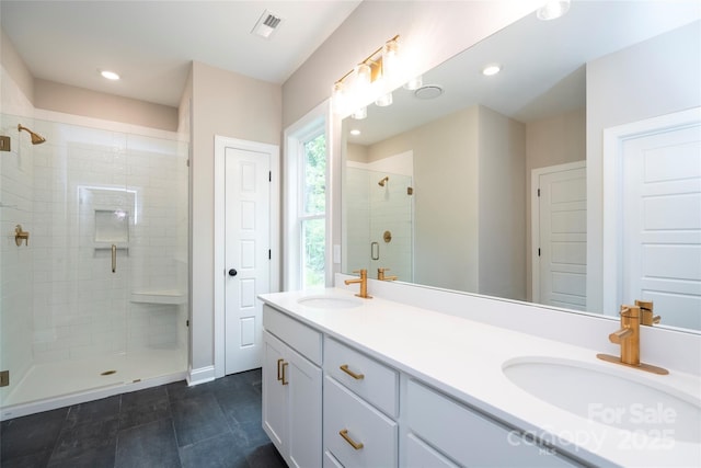 full bath with a stall shower, double vanity, a sink, and visible vents