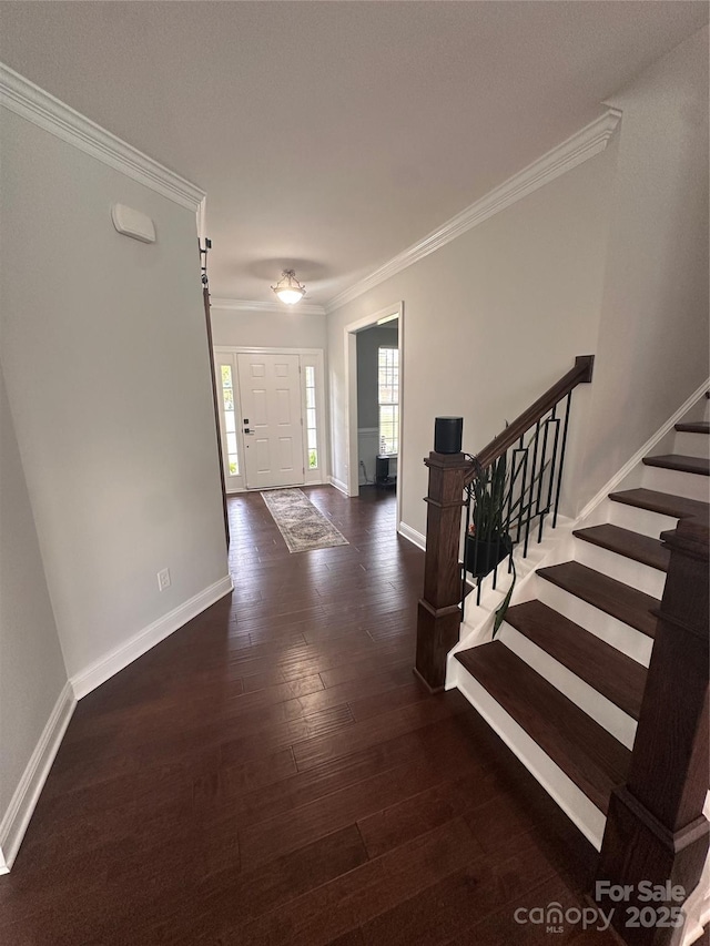 interior space featuring ornamental molding, baseboards, and wood finished floors