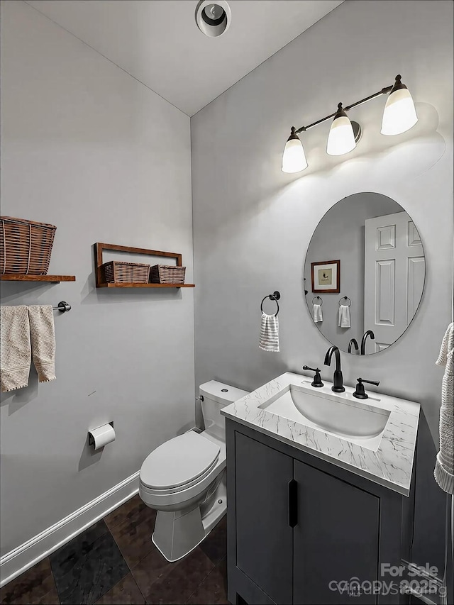 bathroom with tile patterned floors, toilet, vanity, and baseboards