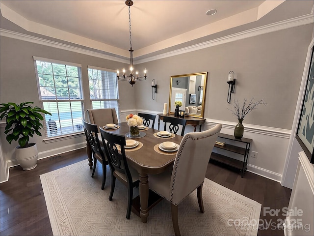 dining room with ornamental molding, visible vents, a tray ceiling, and a chandelier