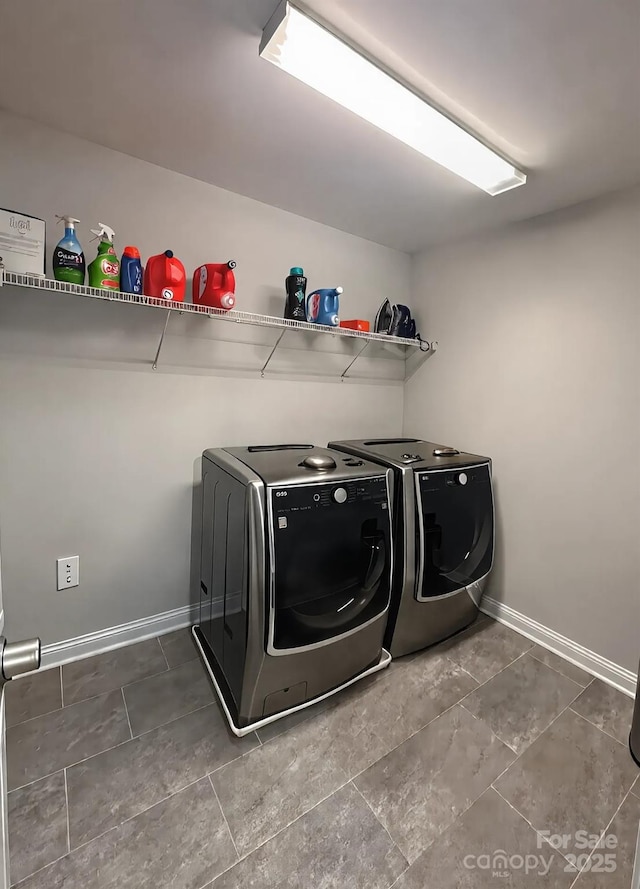 washroom featuring laundry area, separate washer and dryer, and baseboards