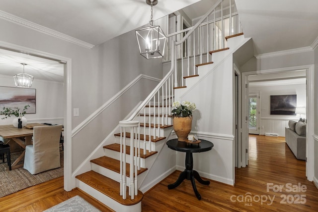 5125 Winding Brook Rd, Charlotte, NC 28226 - staircase featuring ornamental molding, wood finished floors, and an inviting chandelier