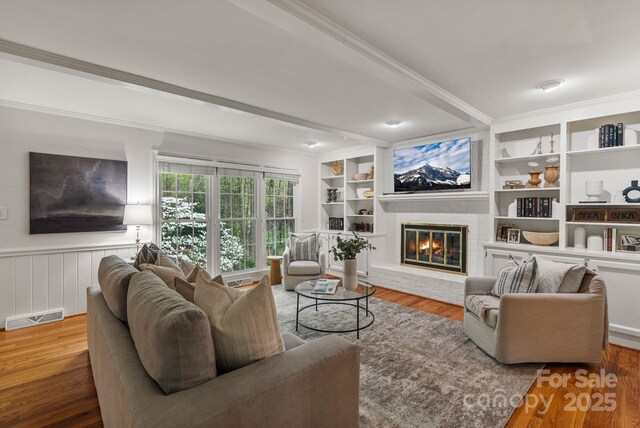 5125 Winding Brook Rd, Charlotte, NC 28226 - living room with a wainscoted wall, visible vents, beamed ceiling, and wood finished floors