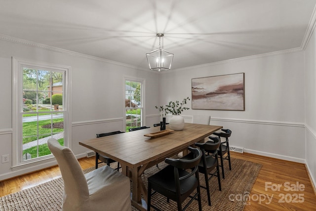 5125 Winding Brook Rd, Charlotte, NC 28226 - dining space with light wood finished floors, visible vents, ornamental molding, and an inviting chandelier