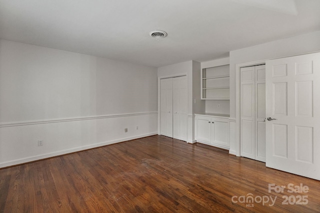 5125 Winding Brook Rd, Charlotte, NC 28226 - unfurnished bedroom featuring dark wood finished floors, baseboards, multiple closets, and visible vents