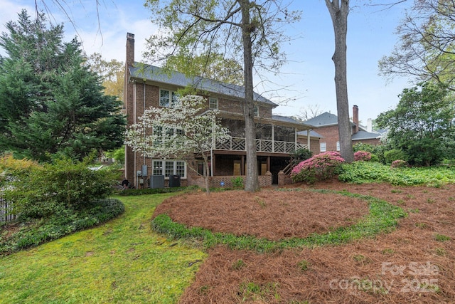 5125 Winding Brook Rd, Charlotte, NC 28226 - rear view of house with a chimney, a sunroom, central air condition unit, brick siding, and a lawn