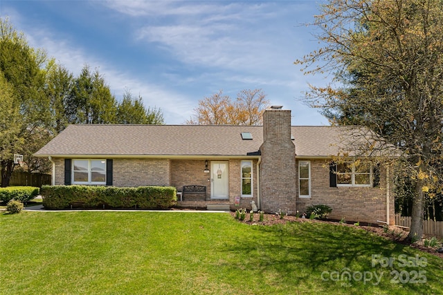 ranch-style home with brick siding, fence, a chimney, and a front lawn