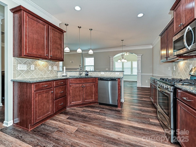 4425 Marlay Park, Indian Trail, NC 28079 - kitchen featuring appliances with stainless steel finishes, a sink, ornate columns, dark wood finished floors, and a peninsula