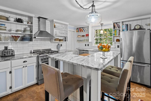 144 Miller Dr, Tryon, NC 28782 - kitchen with open shelves, wall chimney range hood, a kitchen breakfast bar, stainless steel appliances, and backsplash