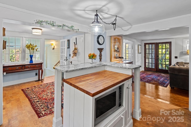 144 Miller Dr, Tryon, NC 28782 - kitchen with open floor plan, light wood-style floors, stainless steel microwave, white cabinetry, and butcher block countertops