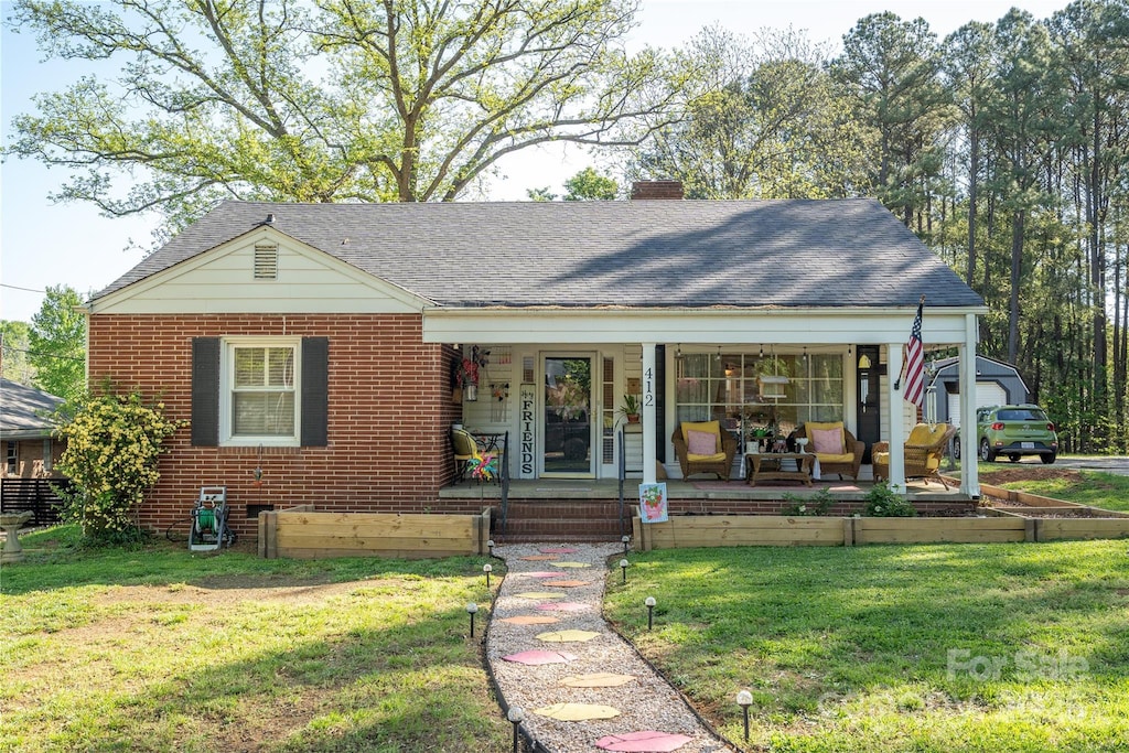 412 W D Ave, Salisbury, NC 28144 - view of front of home featuring roof with shingles, a chimney, a front lawn, and covered porch