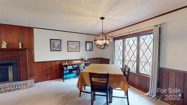 dining area with wooden walls, wainscoting, a textured ceiling, and an inviting chandelier