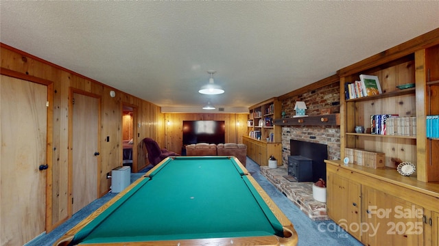 game room with a textured ceiling, wood walls, pool table, and carpet